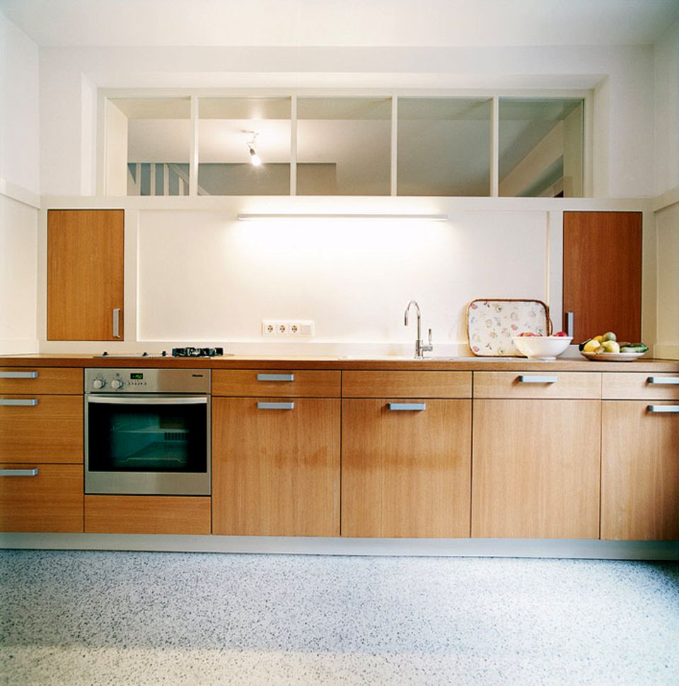 Küche mit Terrazzoboden und hellbraunen Holzfronten.