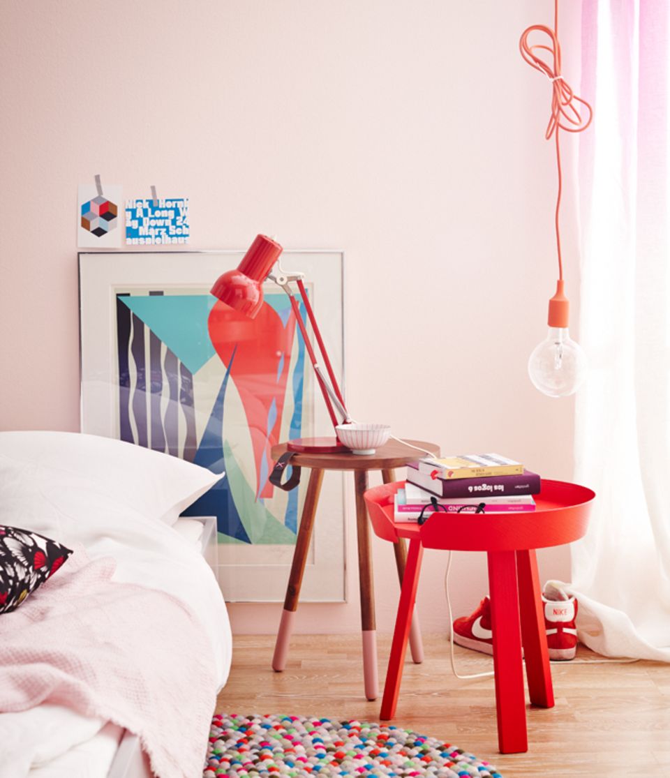 Kleine Beistelltische neben dem Bett: Kräftige Töne wie Rot dominieren von allein und sollten den Schwerpunkt setzen. Mit zu vielen starken Farben wirkt ein Raum schnell überladen.