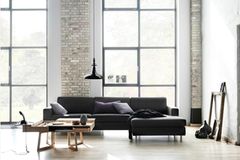 Zeitlos: Weiße Wände, schwarze Sitzmöbel und Möbel aus Holz