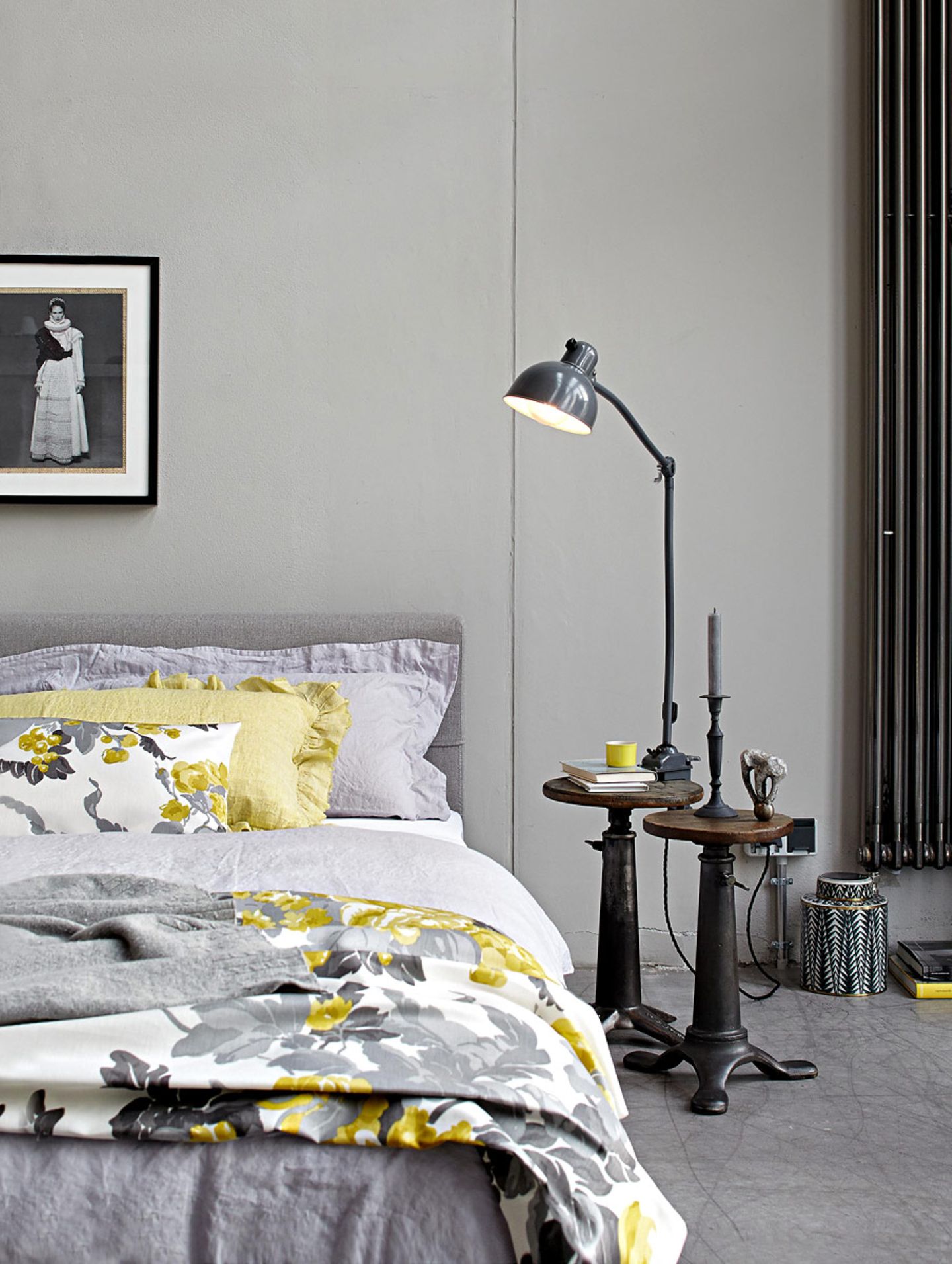 Ein Schlafzimmer in Grau mit Textilien in Senfgelb