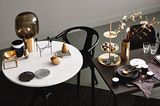 Lässig gedeckter Tisch mit Messing, Schwarz, Marmor und winterlichen Zweigen.