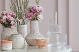 Vasen aus Keramik und Glas vor rosafarbener Wand