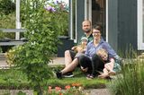 Familie vor Gartenlaube im Schrebergarten