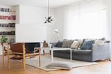 Wohnzimmer mit grauem Sofa und Ledersesseln