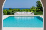 Ibiza: Blick durch die Arkaden auf einen Pool mit langem Outdoorsofa