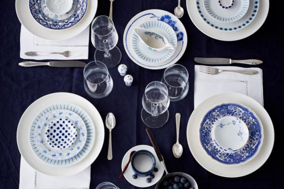 Gedeckter Tisch mit Porzellan in Weiß- und Blautönen