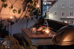 Atmosphärischer Balkon mit gedecktem Tisch zum Abendbrot und mehreren Windlichtern