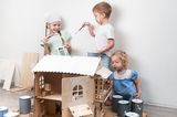 Kinder lackieren ein Spielhaus