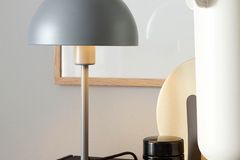 Tischleuchte "Kia" aus der SCHÖNER WOHNEN-Kollektion in Grau in einem Wohnzimmer in Grautönen