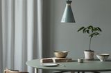 Hängeleuchte "Cone" von Warm Nordic über einem stilvoll dekorierten Tisch