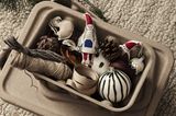 Weihnachtsbaumschmuck in Form von Anhängern und Kugeln in einer kleinen Kiste
