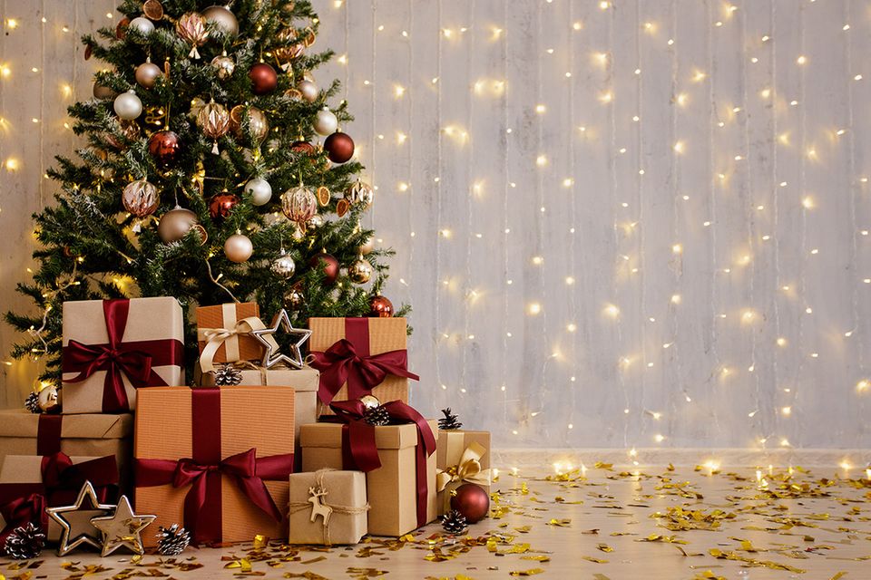 Stilvoll geschmückter Weihnachtsbaum umringt von zahlreichen Geschenken