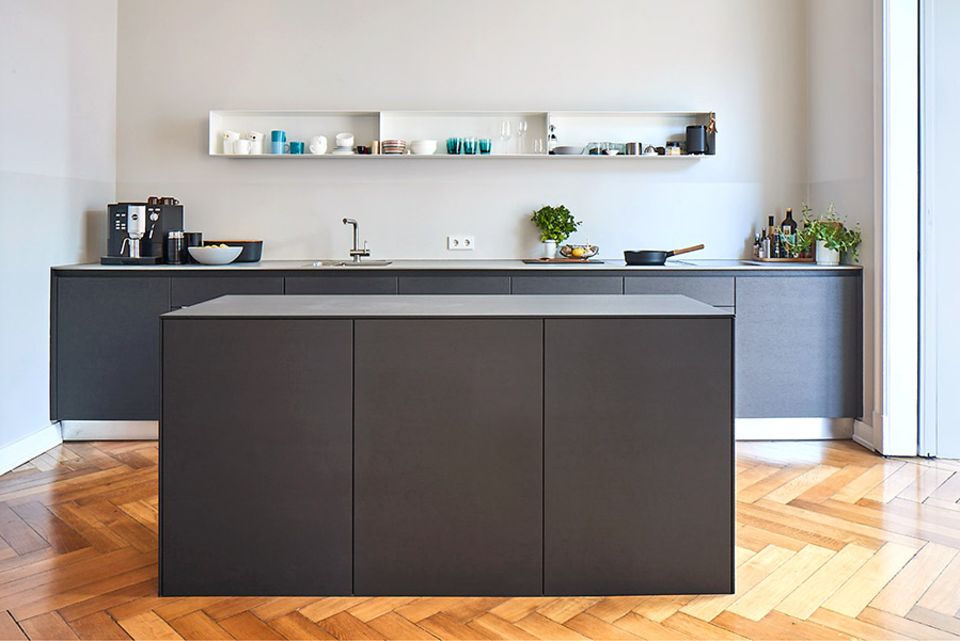 Schwarze Küche mit Eichenparkett und einer Arbeitsplatte aus 1 cm dickem Beton
