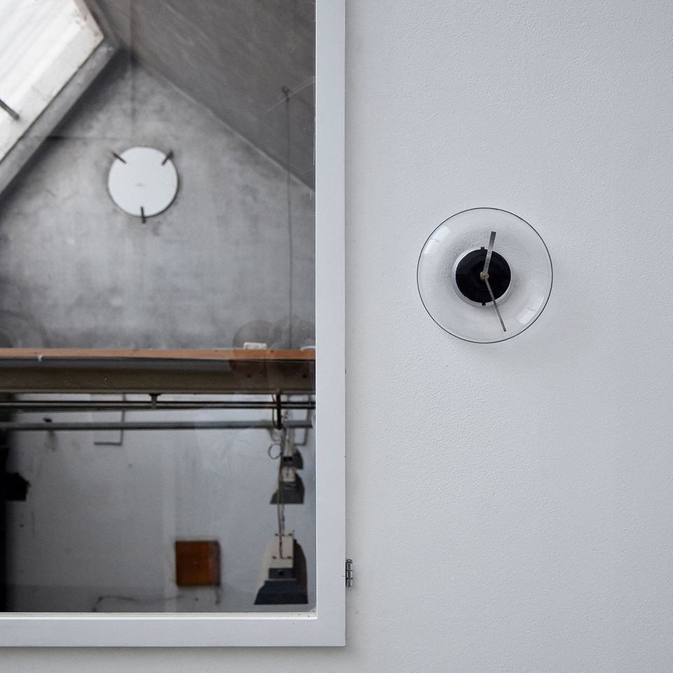 Uhr aus Glas hängt an einer Wand Uhr aus Glas hängt an einer Wand