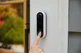 Eine Frau betätigt Arlos "Video Doorbell Wire Free" mit dem Zeigefinger
