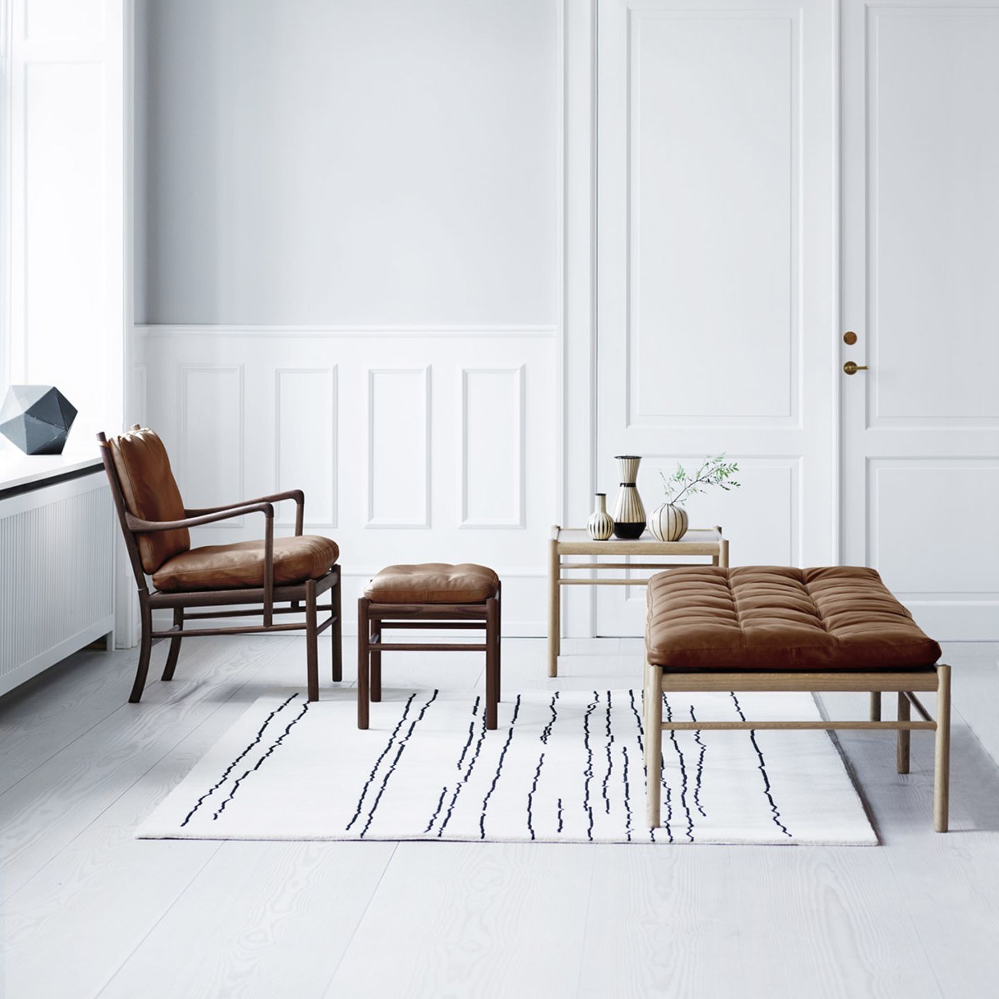 Minimalistisch eingerichtetes Wohnzimmer mit Sessel und Daybed