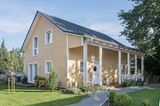 Idyllisches Schwedenhaus von Schwörer mit Vorgarten und einer Fassade in Goldocker