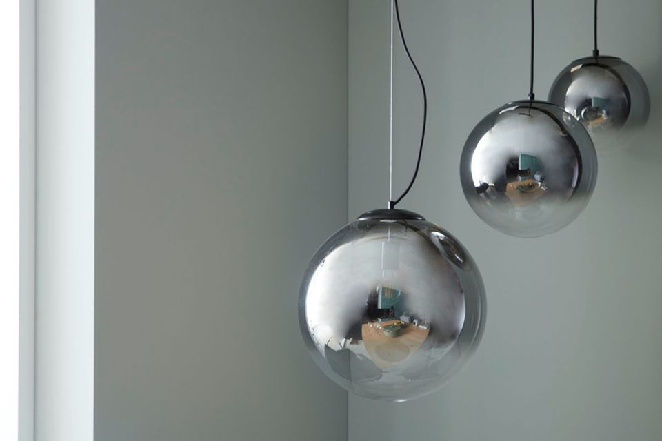 Pendelleuchte "Mirror" aus der SCHÖNER WOHNEN-Kollektion vor einer grauen Wand