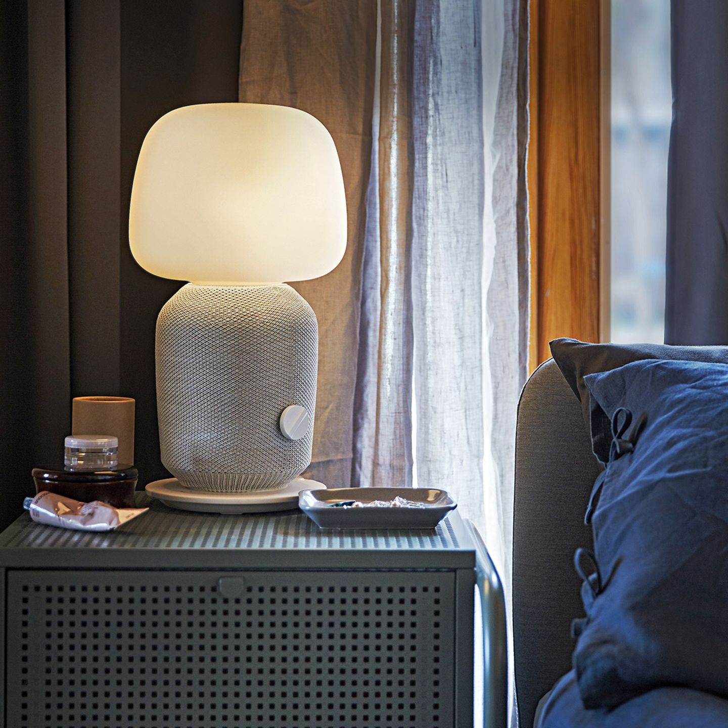 Tischleuchte "Symfonisk" von Ikea mit WiFi auf einem Nachttisch neben einem Bett