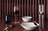 Rotweinglas "Essence" von Ittala auf einem Tisch mit zwei Schalen, Besteck, einem Wasserglas sowie einem Teelichthalter