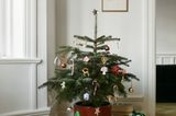Kleiner geschmückter Weihnachtsbaum in einem hellen Wohnzimmer