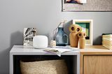 Nest Wifi Repeater von Google auf einem halbhohen Regal mit Tischdeko
