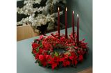 Adventskranz mit roten Beeren, Weihnachststernen und schmalen Kerzen