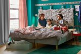 Mutter, Vater und Kind in einem DIY-Familienbett von IKEA
