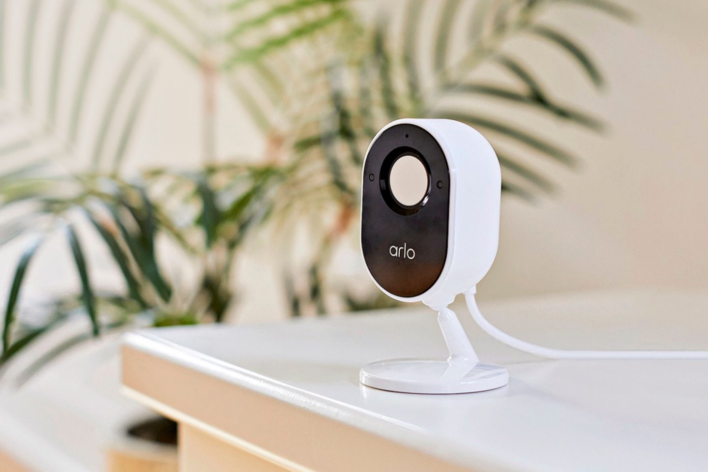 Die kabelgebundene Überwachungskamera "Essential Indoor Cam" von Arlo auf einem Regal