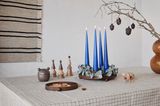 Adventskranz mit blauen Kerzen auf Tisch mit Naturfarben