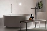 Luxuriöses Badezimmer mit kreisrunder, frei stehender Badewanne – entworfen von Norm Architects
