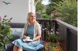 Joanna Kahlau-Allam auf dem Outdoorsofa auf dem Balkon