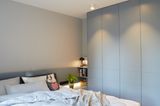 Elternschlafzimmer mit graublauem Einbauschrank und grauer Wand