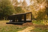 Cabin mit schwarzer Holzfassade in der Natur