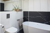 Kleines Badezimmer mit Badewanne und Marmorboden und -wänden