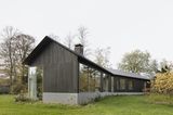 Langgestrecktes Holzhaus mit verglasten Seitenwänden