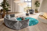 Sofa "Teratai" von Bretz in einem großen Wohnzimmer mit türkisfarbenem Teppich und Kamin