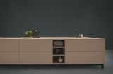 Kochinsel "NX 510 | NX 640" von next125 in Beige vor dunklem Hintergrund