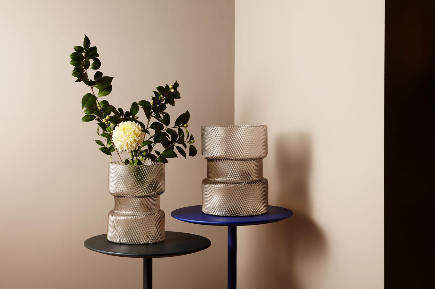 Zwei Vasen mit Reliefmuster vor sandfarbener Wand