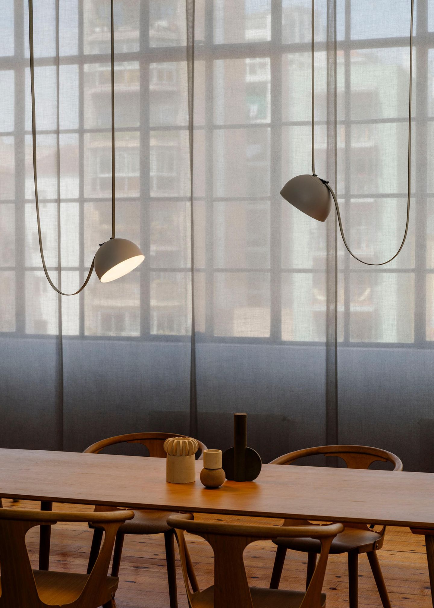 Leuchte "Plusminus" von Stefan Diez für Vibia in Grau über einem Holztisch