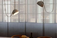 Leuchte "Plusminus" von Stefan Diez für Vibia in Grau über einem Holztisch