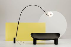 Leuchte "Alicanto" von Fontana Arte vor einem gelben Rechteck und einem runden Couchtisch in Schwarz