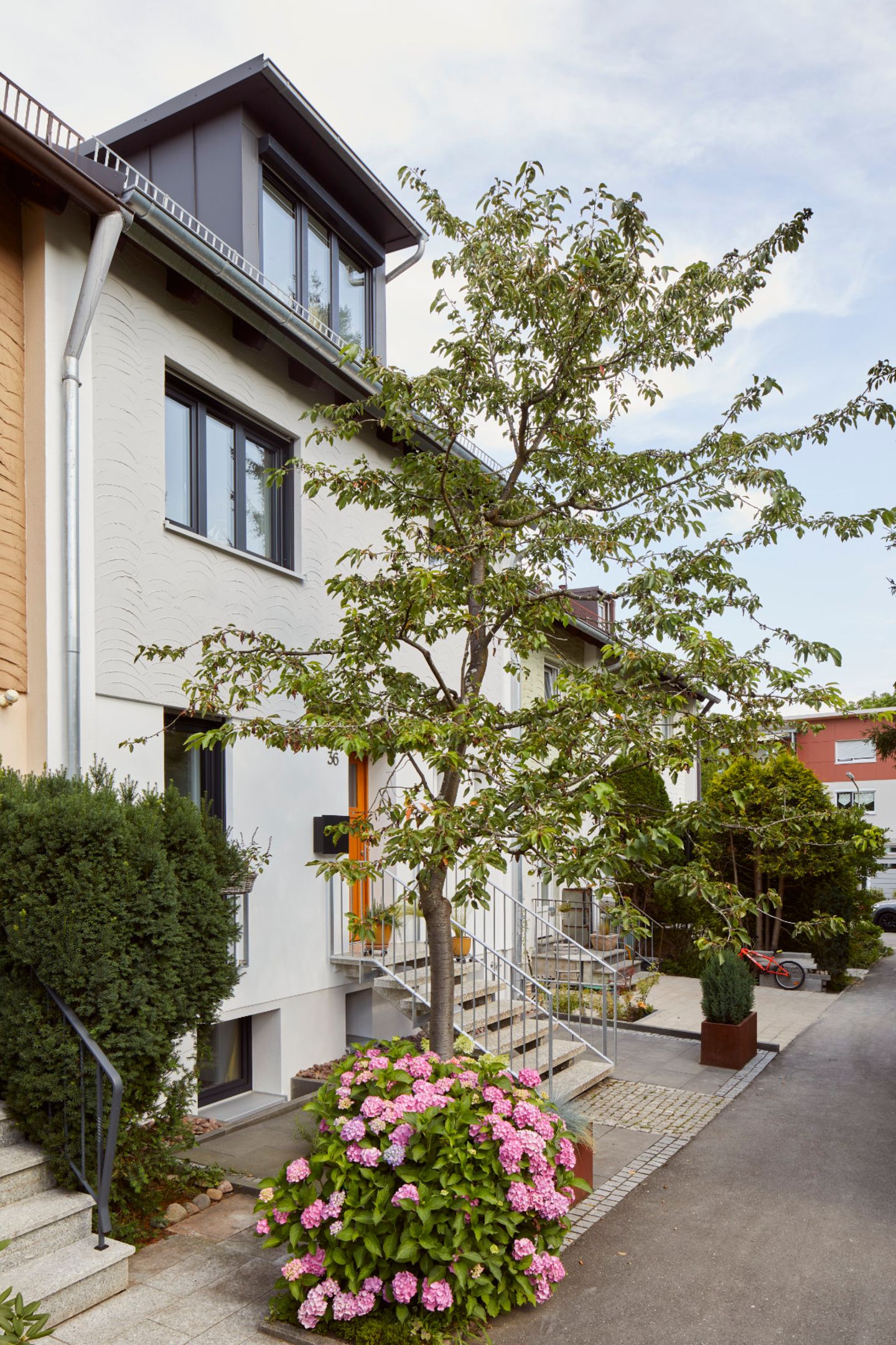 Fassade des Reihenhauses mit Stahltreppe zum Eingang