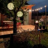 Terrasse einer Gartenlaube mit Lampions während eines Sommerabends