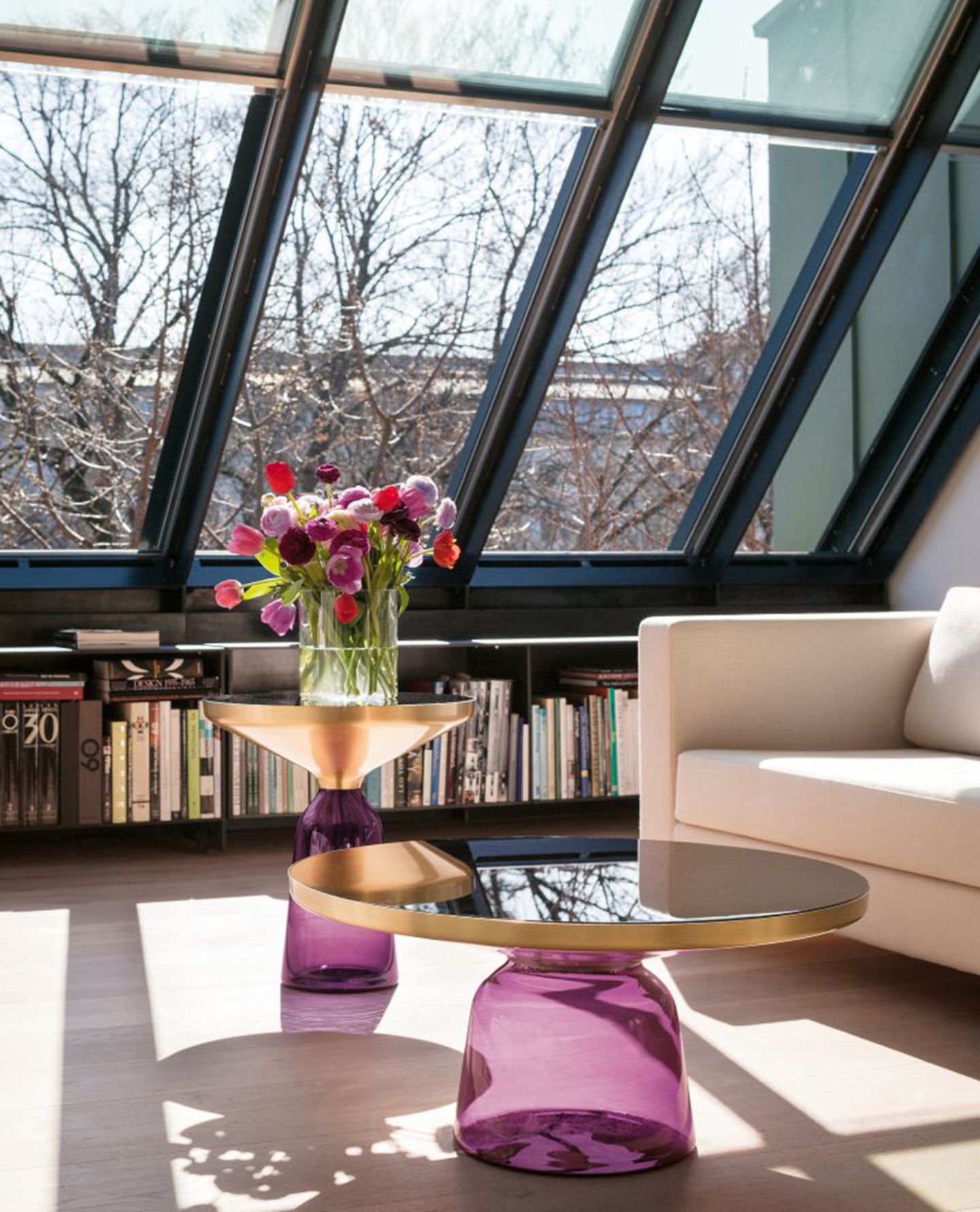 "Bell Table" von Classicon in einem Wohnzimmer mit verglaster Dachschräge