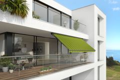 Breiter Balkon mit grün-gestreifter Gelenkarmmarkise "930" von Markilux