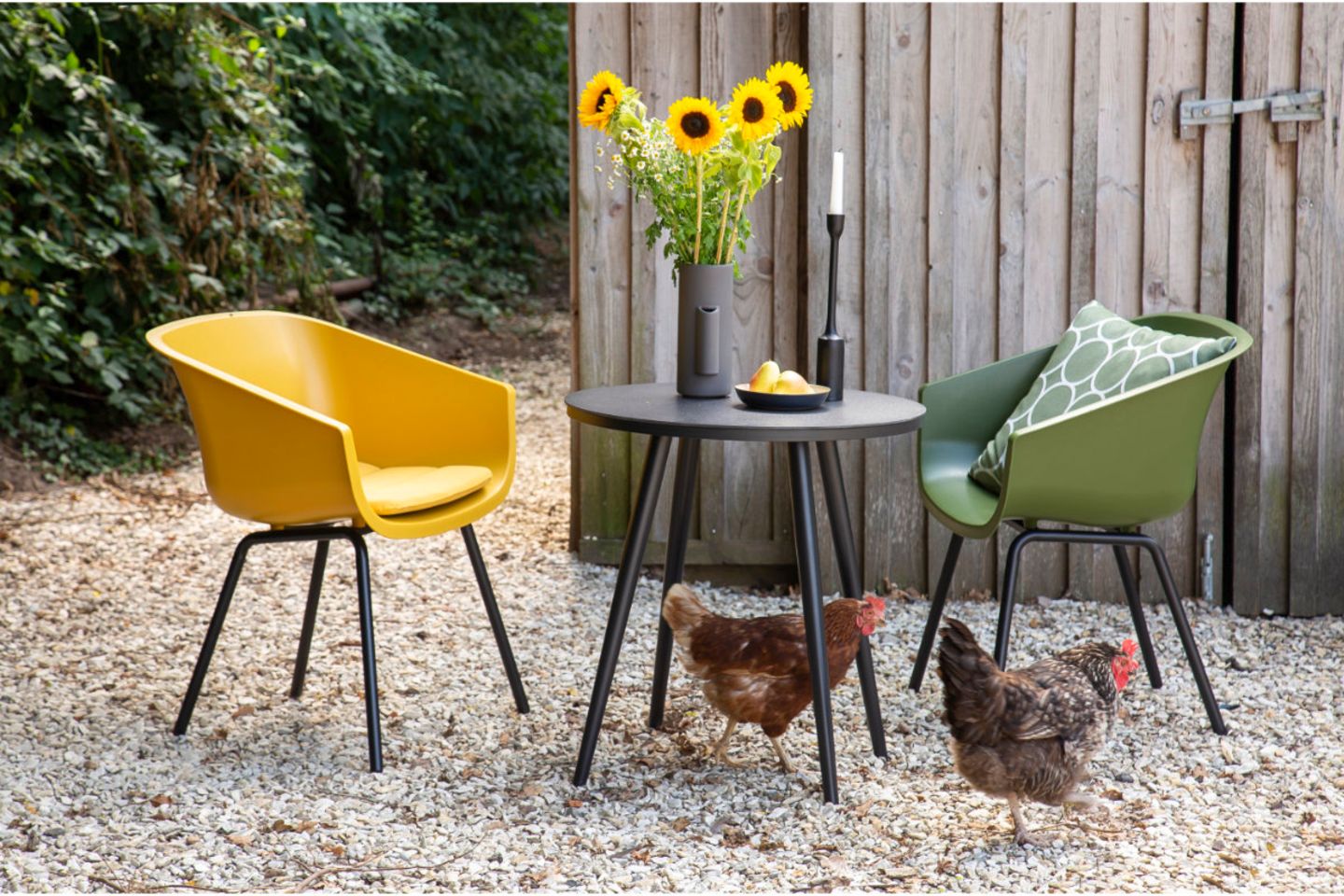 Schalenstühle in Gelb und Grün mit Bistrotisch, Hühner auf dem Boden