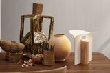 Tischleuchte "Petal Lamp" von Carl Hansen auf einem Holztisch mit verschiedenen Vasen und Skulpturen
