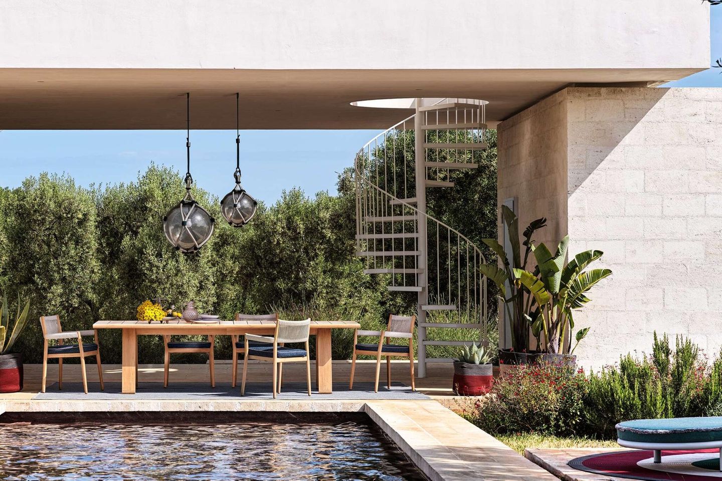 Gartentisch "Dine Out" von Cassina auf einer überdachten Terrasse mit einem Pool im Vordergrund