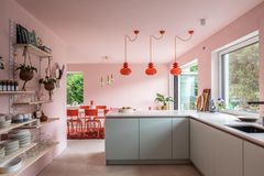Küche im Stil der 60er-Jahre mit rosaroter Wandfarbe